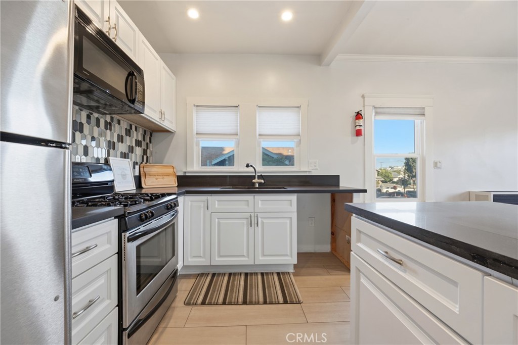 325 East 14th Street Long Beach, CA 90813 - Photo 11 of 21 a kitchen with a sink stove and cabinets
