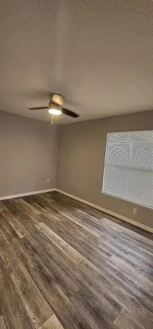 a view of a room with wooden floor and white walls