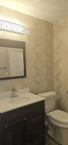 a bathroom with a sink a toilet and a mirror