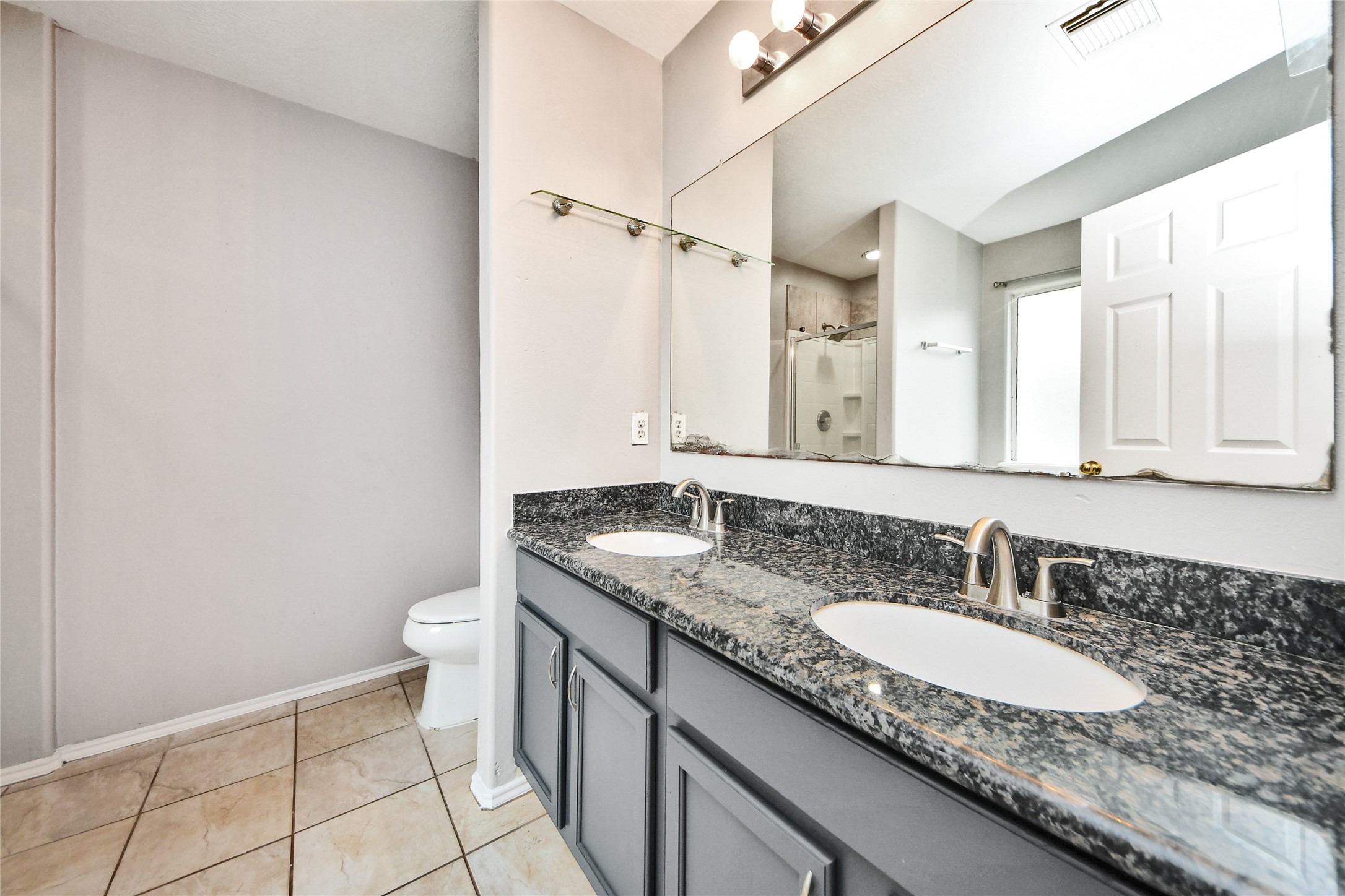 24019 Kingbriar Drive Spring, TX 77373 - Photo 31 of 41 The primary ensuite includes a wide double vanity with dark granite-style countertops and updated cabinetry, offering plenty of space for morning routine