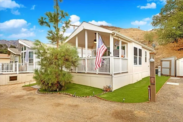 a view of a white house with large windows and a small yard