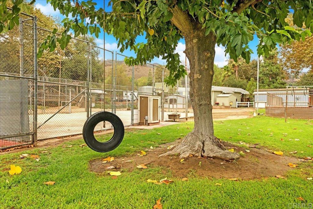 1631 Harbison Canyon Road, Unit 24 El Cajon, CA 92019 - Photo 29 of 33 a view of a yard with yellow house and wooden fence