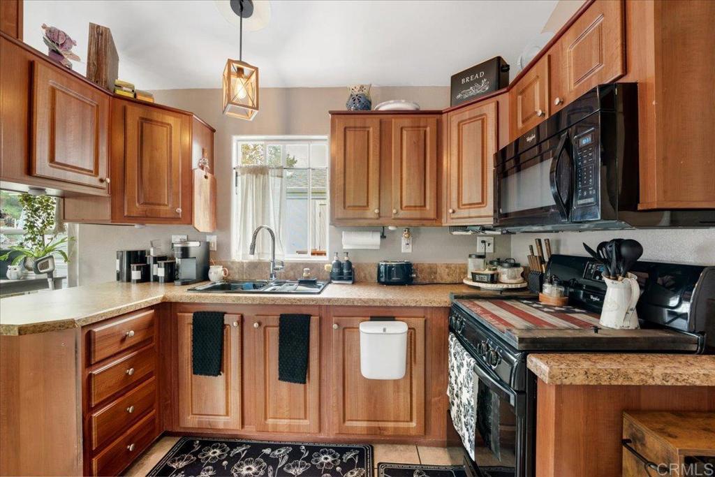 1631 Harbison Canyon Road, Unit 24 El Cajon, CA 92019 - Photo 7 of 33 a kitchen with stainless steel appliances granite countertop a stove a sink dishwasher and cabinets with wooden floor