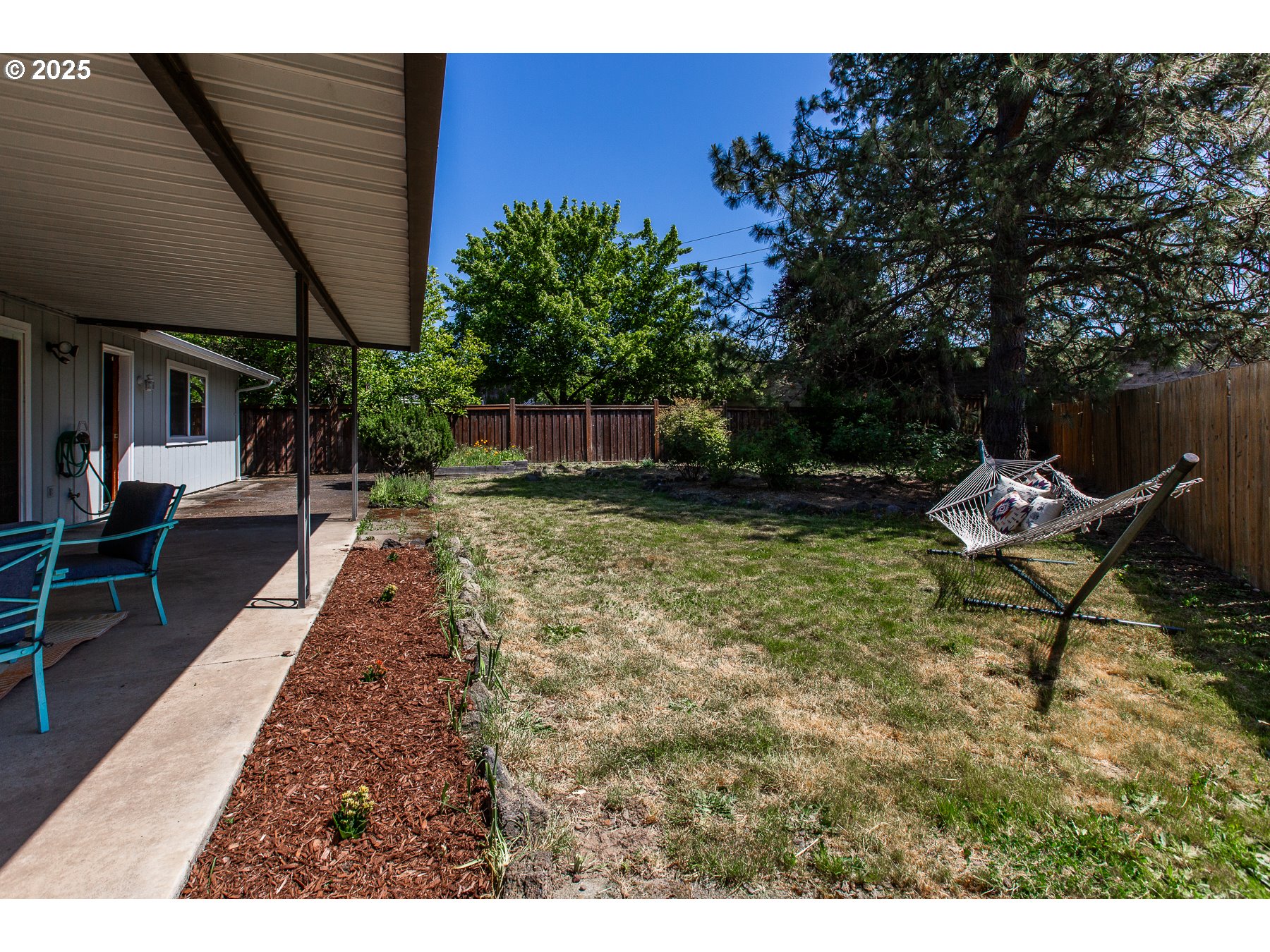 1403 Haven Street Eugene, OR 97402 - Photo 26 of 31 a view of a backyard with chairs potted plants and large tree