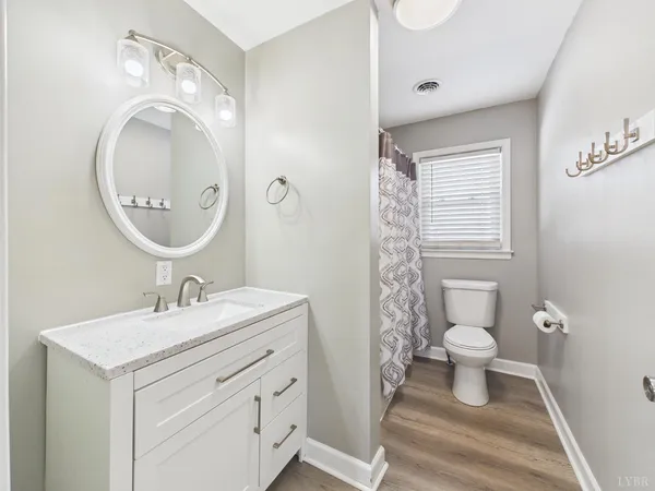 a large kitchen with granite countertop a sink a stove top oven and cabinets