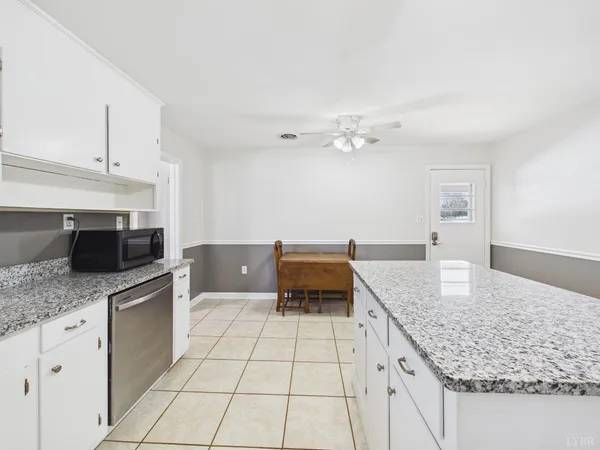 a kitchen with granite countertop white cabinets and white appliances