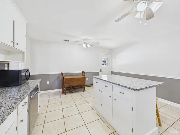 a white house with a large tree in the background