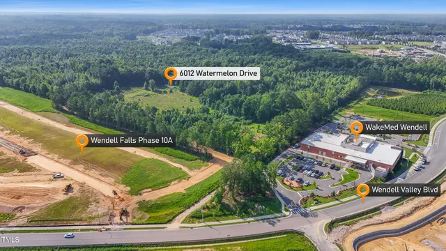 an aerial view of a house with a garden and lake view