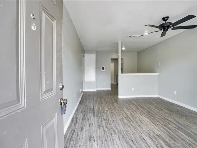 a view of a livingroom with a ceiling fan and wooden floor
