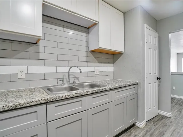 a bathroom with a granite countertop sink and cabinets
