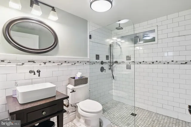 a bathroom with a sink a toilet and a mirror