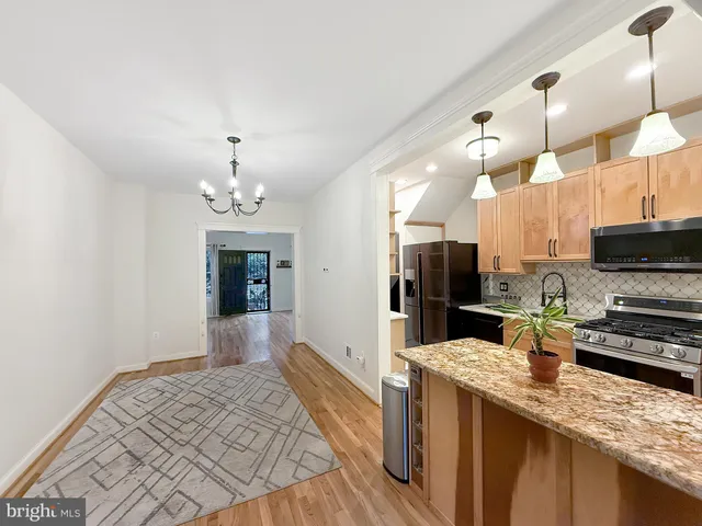 a kitchen with stainless steel appliances granite countertop a sink refrigerator stove and microwave