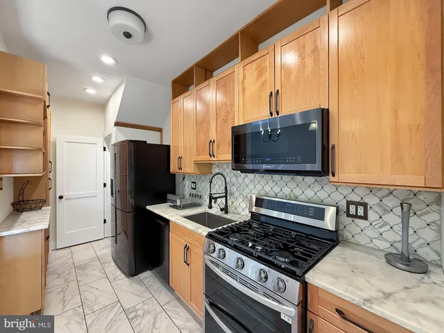 a kitchen with stainless steel appliances granite countertop a stove a sink and a microwave