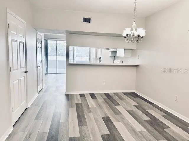 a view of a room with wooden floor and chandelier
