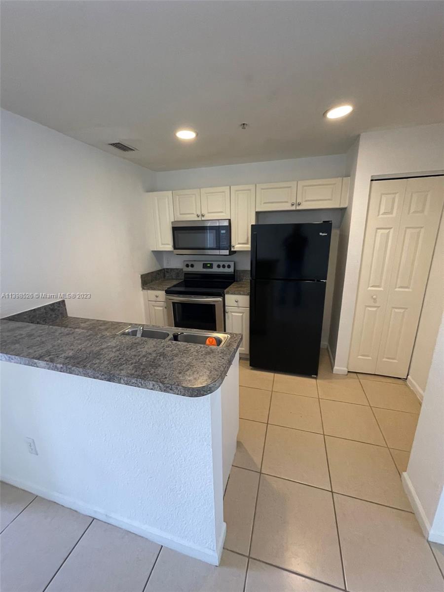 Riviera Beach Riviera Beach, FL 33404 - Photo 4 of 20 a kitchen with a sink a refrigerator and cabinets