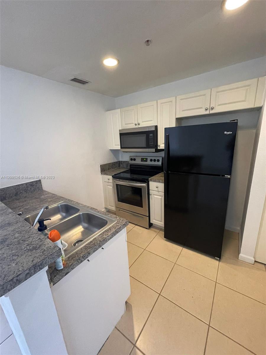 Riviera Beach Riviera Beach, FL 33404 - Photo 5 of 20 a kitchen with granite countertop a stove and a refrigerator