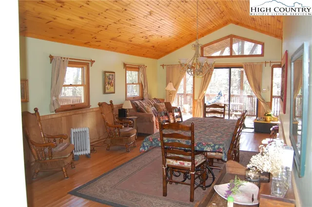 a dining room with wooden floor windows and chairs