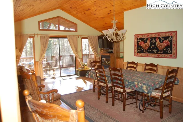 a view of a dining room with furniture a chandelier and wooden floor