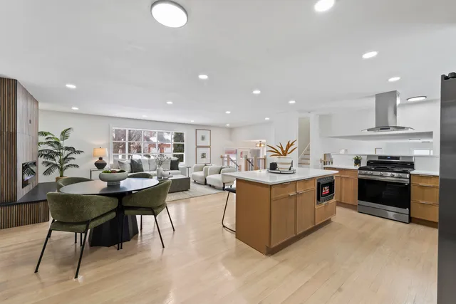 a kitchen with stainless steel appliances granite countertop a table and chairs in it
