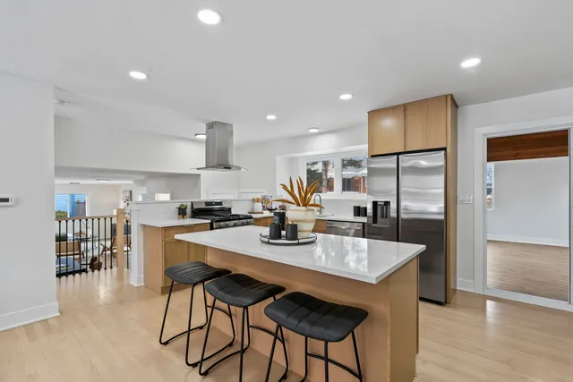 a kitchen with counter space dining table and wooden floor