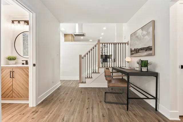 a view of a hallway with wooden floor and furniture