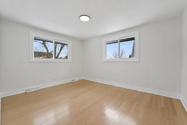 a view of an empty room with a window and a painting on the wall