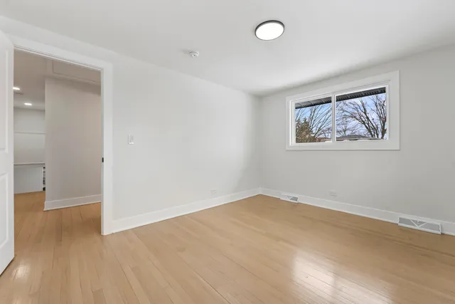 an empty room with a painting and a lamp