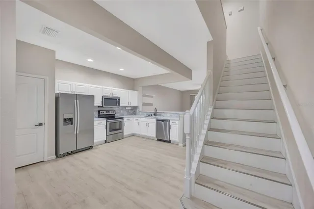 a kitchen with cabinets and white stainless steel appliances