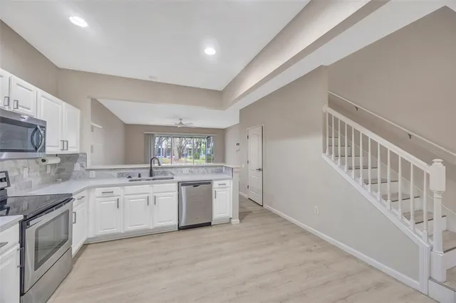 a kitchen with sink and white cabinets