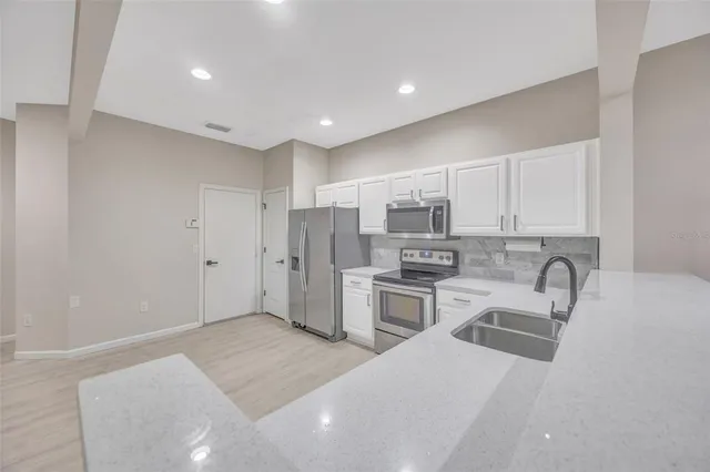 a kitchen with stainless steel appliances a refrigerator sink and microwave