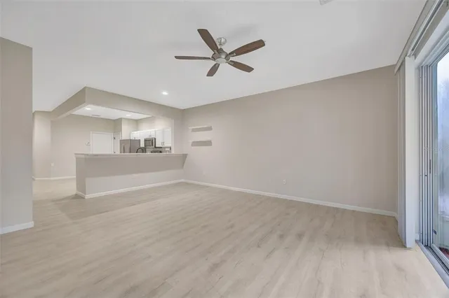 a view of a livingroom with a ceiling fan & wooden floor
