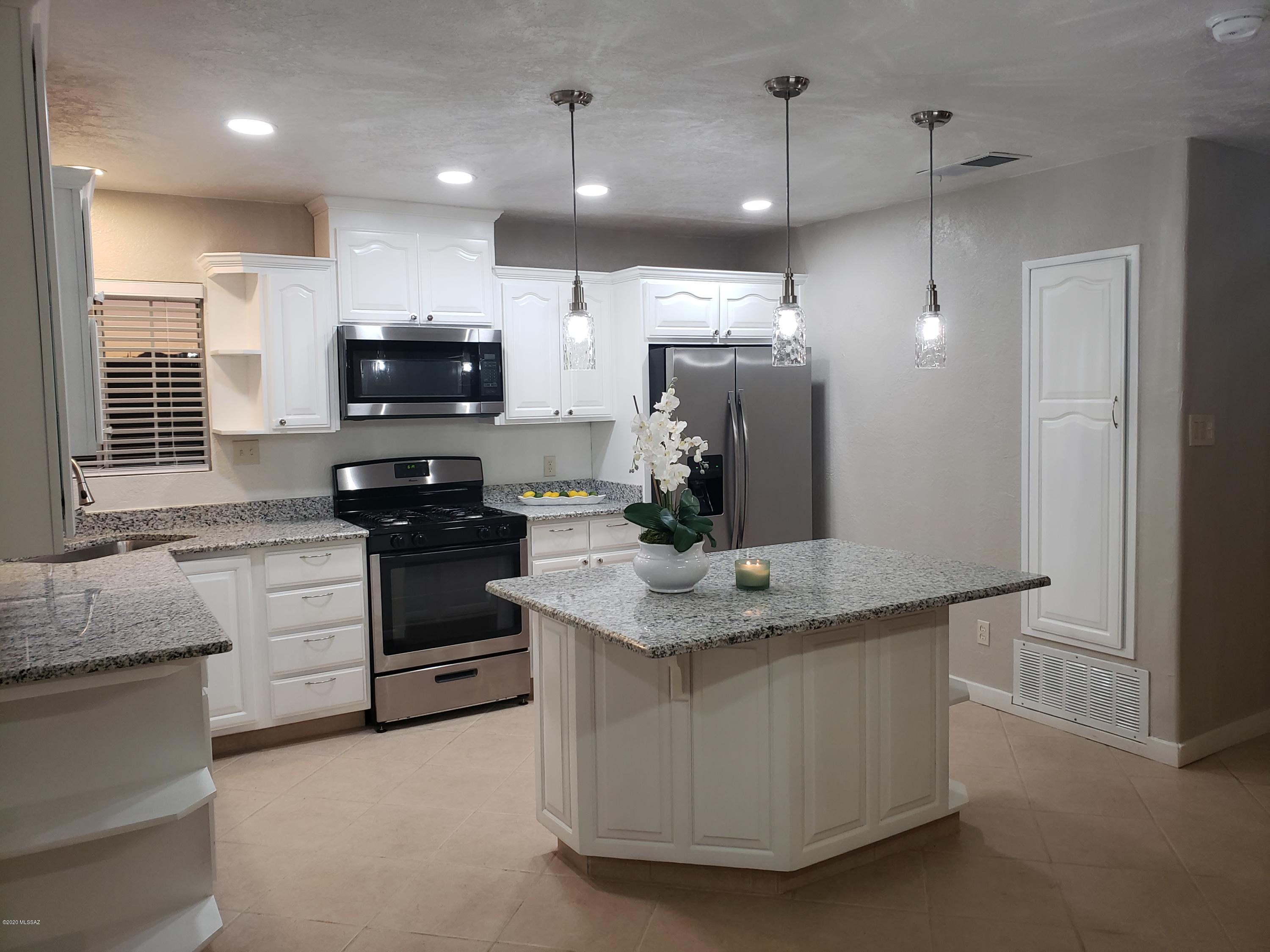 182 Pita Court Rio Rico, AZ 85648 - Photo 14 of 46 a kitchen with stainless steel appliances kitchen island granite countertop a stove a sink and a refrigerator
