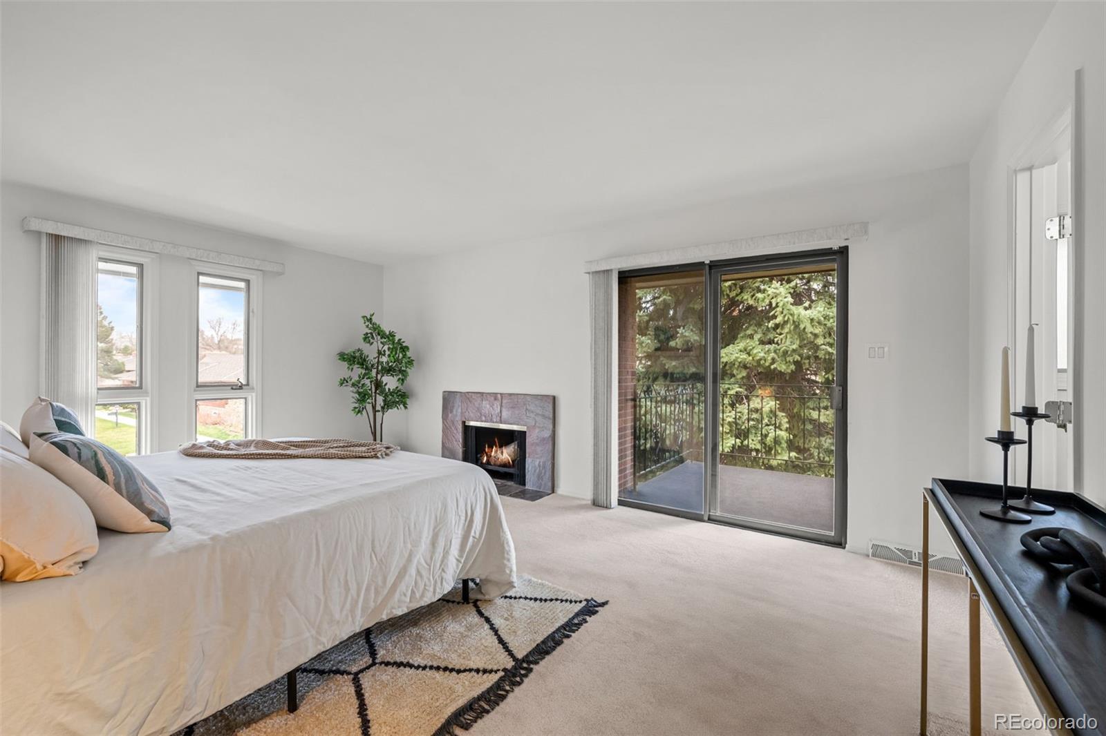 3436 South Race Street Englewood, CO 80113 - Photo 25 of 49 a spacious bedroom with a bed a fireplace and windows