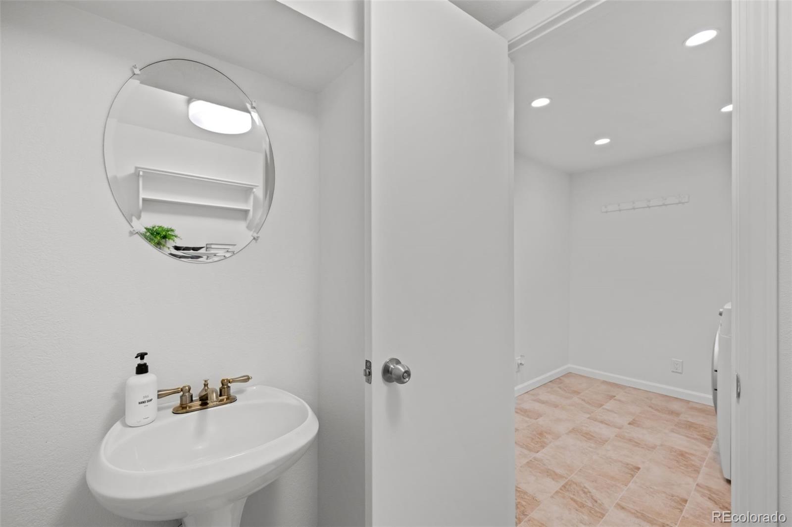 3436 South Race Street Englewood, CO 80113 - Photo 36 of 49 a bathroom with a sink a mirror and a vanity