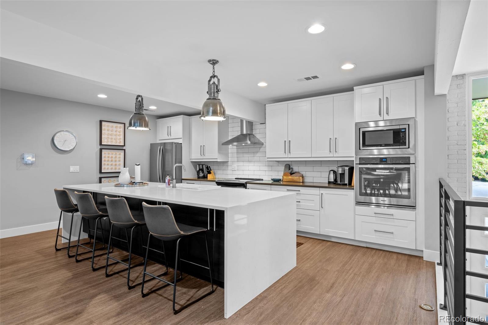 3436 South Race Street Englewood, CO 80113 - Photo 44 of 49 a kitchen with kitchen island cabinets and wooden floor