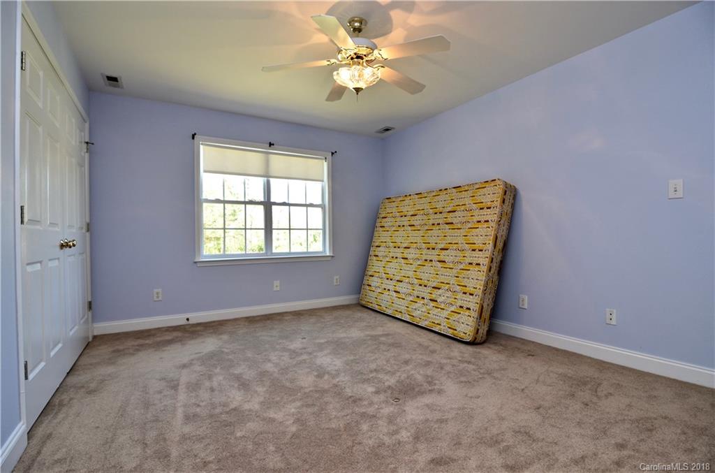 5208 Austin Road Monroe, NC 28112 - Photo 20 of 36 an empty room with windows and chandelier fan