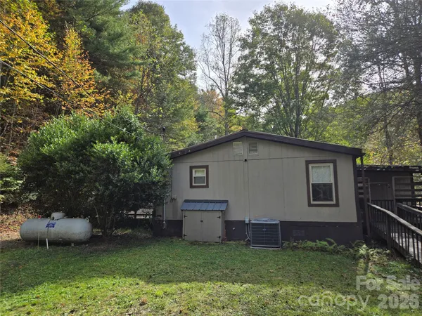 a view of a house with backyard and a tree