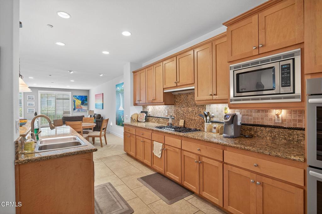 1423 Windshore Way Oxnard, CA 93035 - Photo 75 of 77 a kitchen with stainless steel appliances granite countertop a stove top oven a sink dishwasher and cabinets with wooden floor