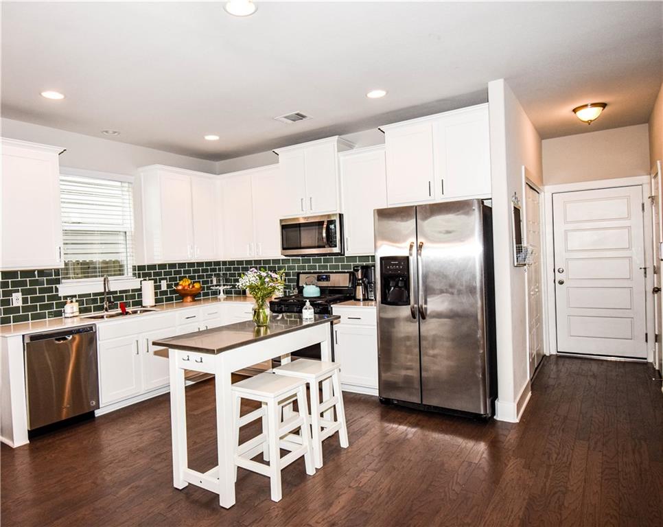 a kitchen with stainless steel appliances a refrigerator a stove top oven and sink