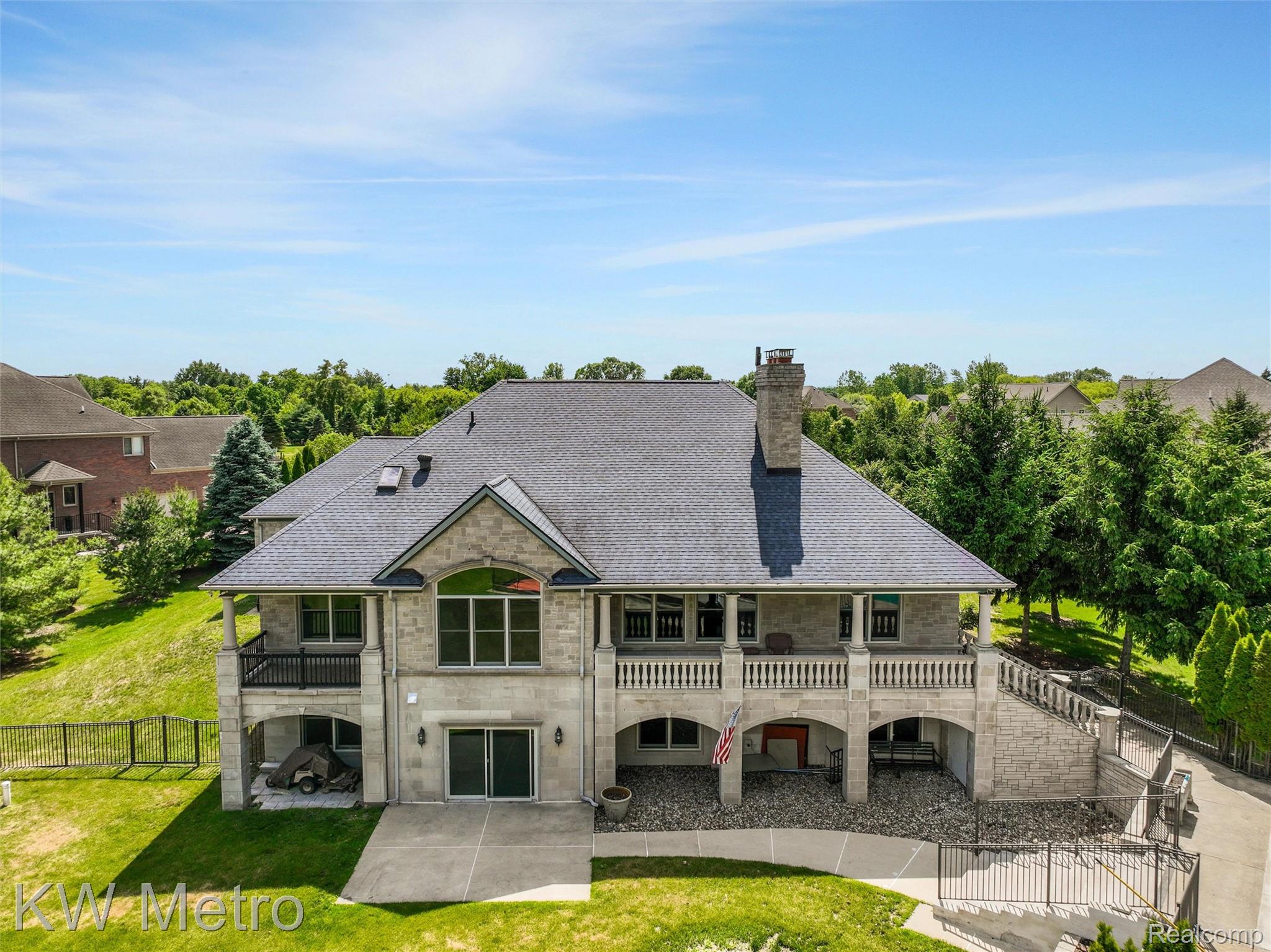 65884 Windrose Court Ray, MI 48096 - Photo 18 of 82 Stone exterior with multiple balconies and a lower-level patio
