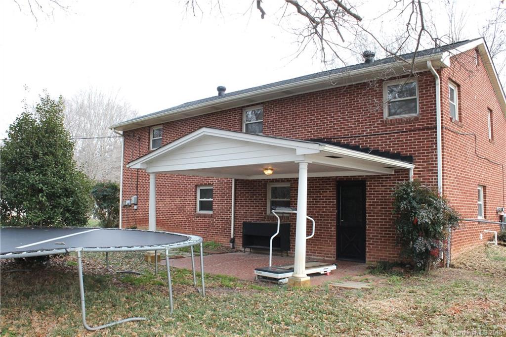 4335 Beaty Road Gastonia, NC 28056 - Photo 22 of 22 a view of a house with a yard and lawn chairs under an umbrella