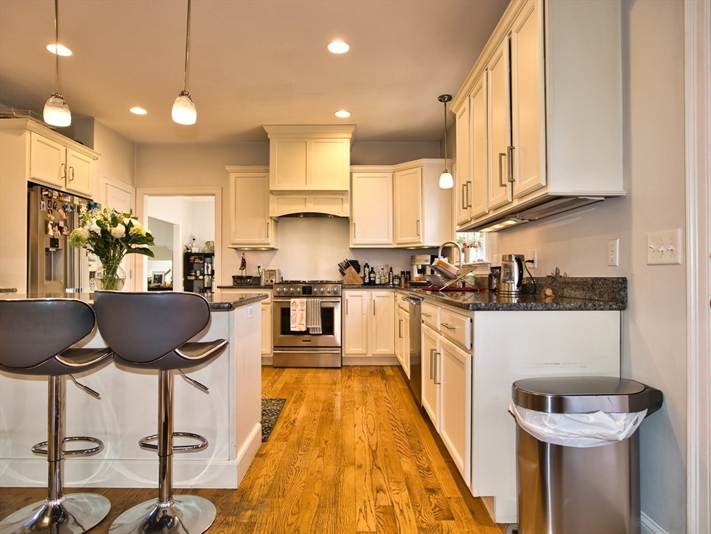 9 Brookfield Lane Bellingham, MA 02019 - Photo 11 of 40 a kitchen with granite countertop a stove a sink a counter space and cabinets