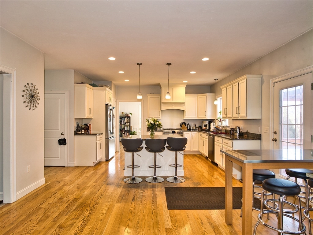 9 Brookfield Lane Bellingham, MA 02019 - Photo 13 of 40 a living room with stainless steel appliances kitchen island granite countertop furniture and a wooden floor