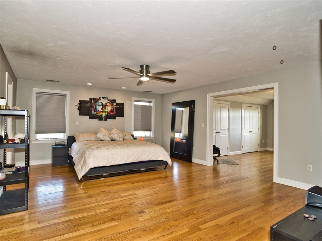 9 Brookfield Lane Bellingham, MA 02019 - Photo 24 of 40 a spacious bedroom with a large bed and a chandelier