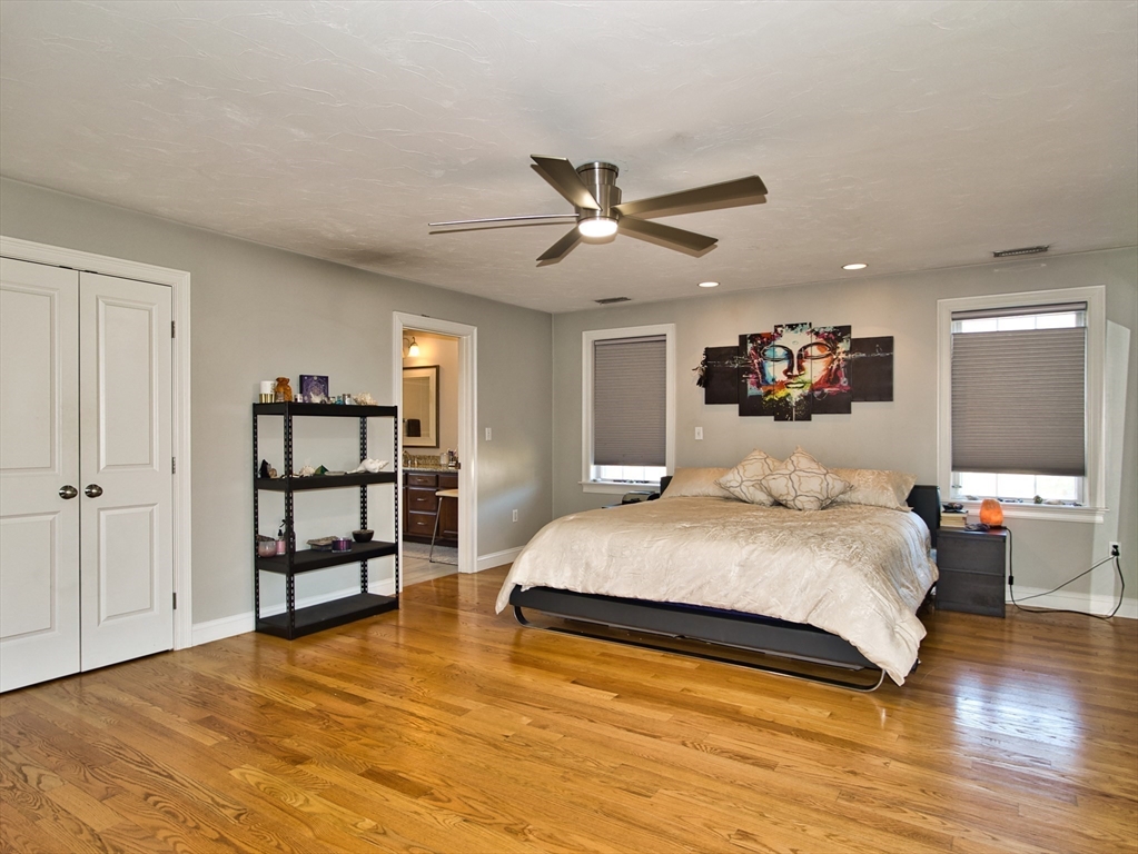 9 Brookfield Lane Bellingham, MA 02019 - Photo 25 of 40 a bedroom with a large bed and a chandelier