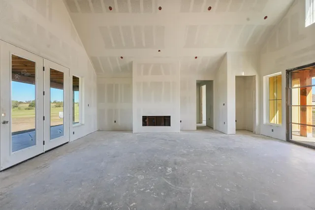 a view of an empty room with a fireplace and a window