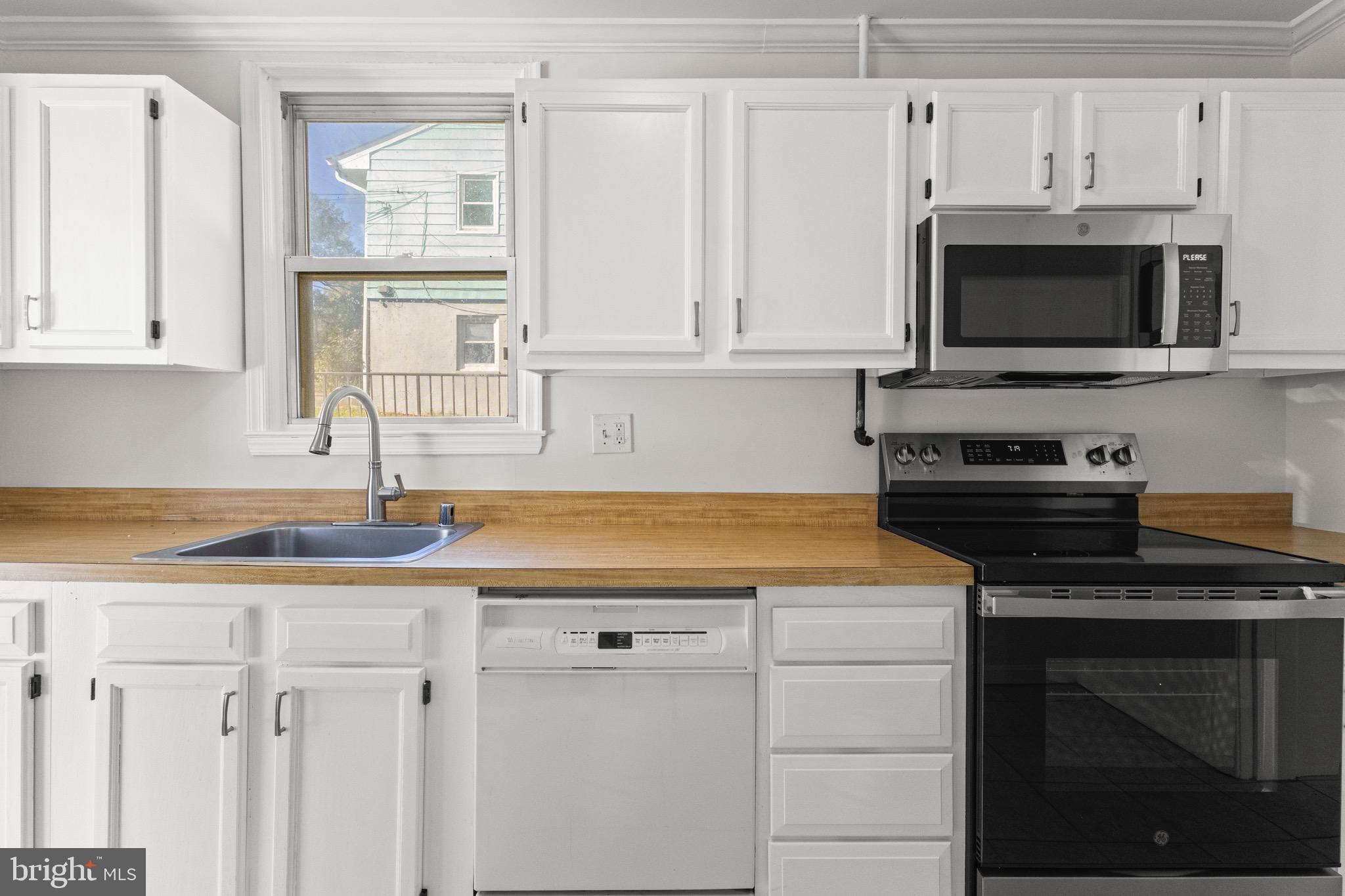 5120 Kenesaw Street College Park, MD 20740 - Photo 11 of 37 a kitchen with granite countertop white cabinets and black appliances
