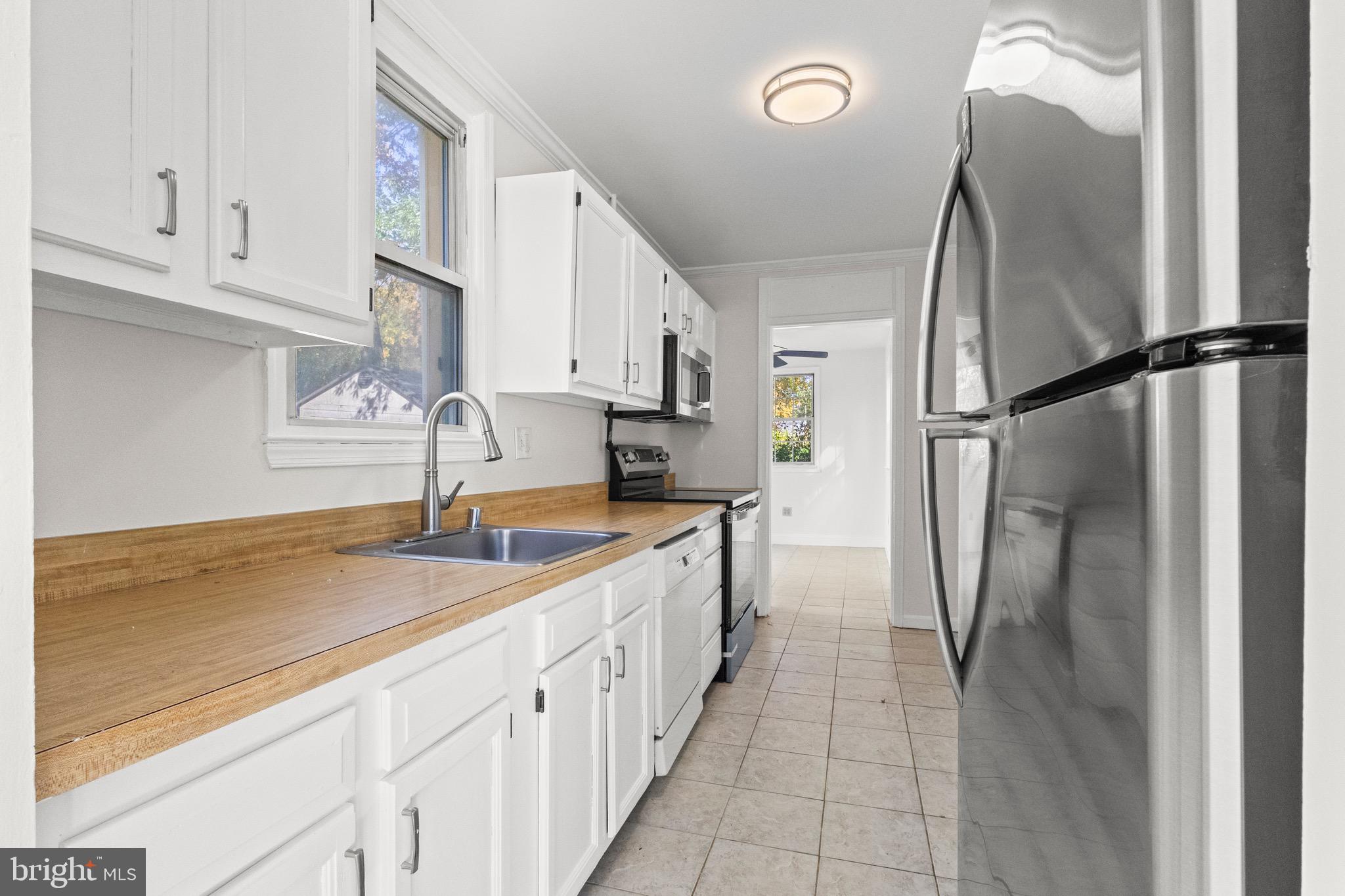 5120 Kenesaw Street College Park, MD 20740 - Photo 10 of 37 a kitchen with stainless steel appliances granite countertop a refrigerator a sink and white cabinets