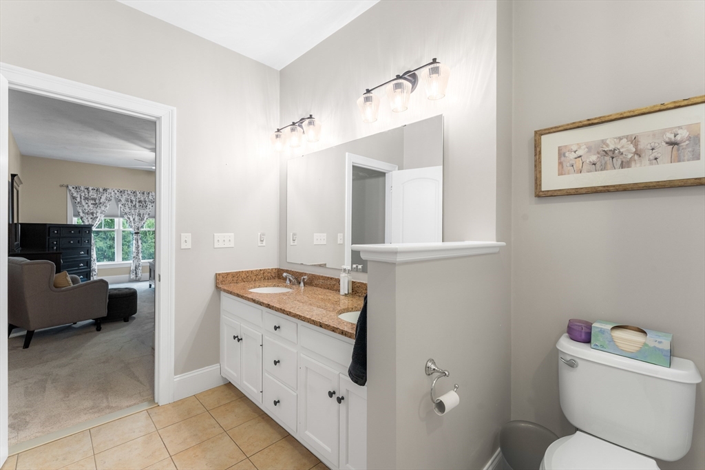 4 Hawthorne Path, Unit 4 Milford, MA 01757 - Photo 17 of 28 a bathroom with a granite countertop toilet sink and mirror