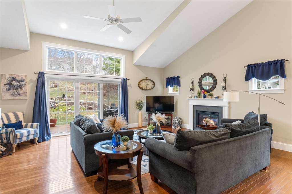 4 Hawthorne Path, Unit 4 Milford, MA 01757 - Photo 10 of 28 a living room with furniture a fireplace and a floor to ceiling window